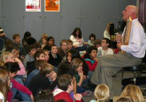 Evo Bluestein leads singing in the multi-cultural American folk music assembly.