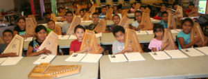 Students play and sing during the folk music week with autoharps.