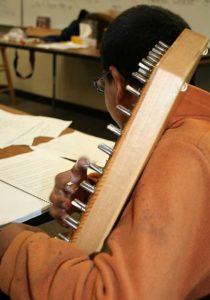 Fifth grade student playing autoharp.